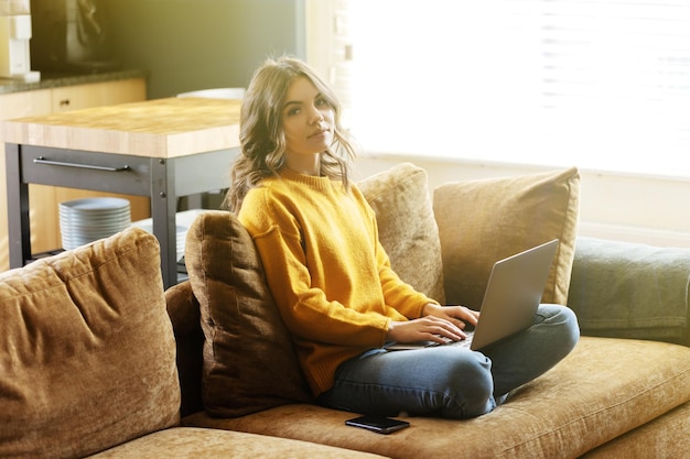 Ragazza che lavora a casa con un laptop durante la quarantena