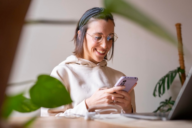 ragazza che lavora a casa Ragazza che utilizza cellulare sorridente durante il lavoro