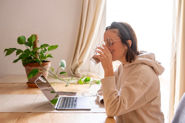 ragazza che lavora a casa Ragazza davanti al computer con una tazza di caffè