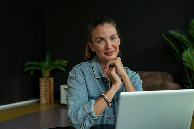 Ragazza che lavora su un laptop in una caffetteria alla moda