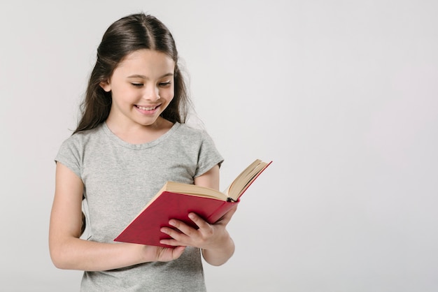 Ragazza che legge il libro in studio e sorridente