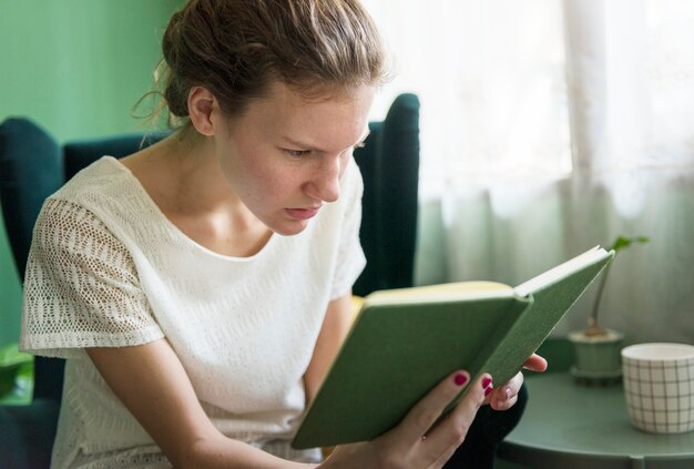 Ragazza che legge un libro a casa