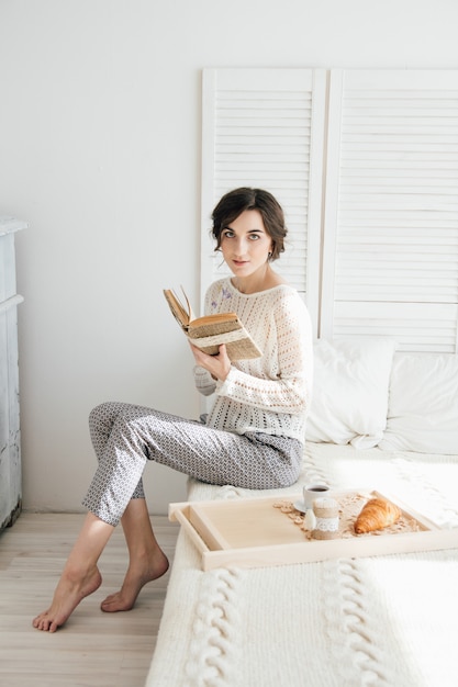 Ragazza che legge un libro a colazione