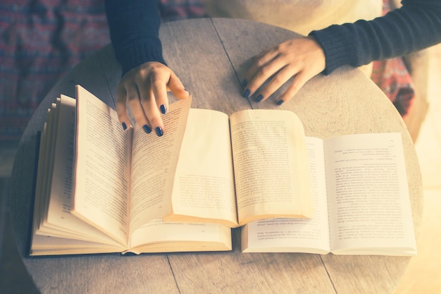 Ragazza che legge un libro al tavolo effetto foto vintage