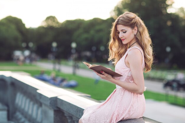 Ragazza che legge un libro nel parco.