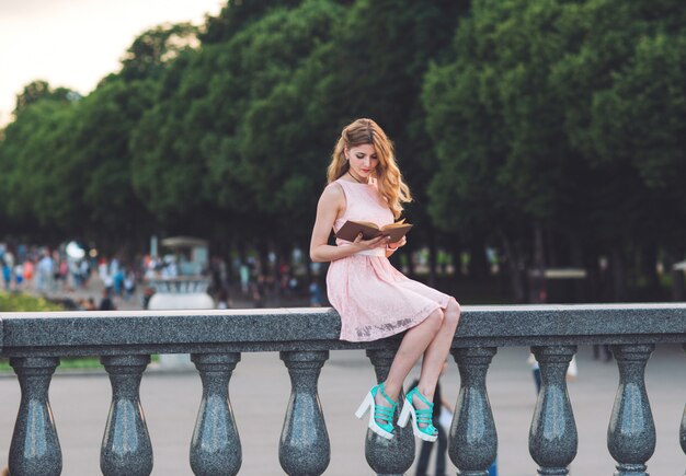 Ragazza che legge un libro nel parco.