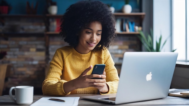 Ragazza che manda messaggi con lo smartphone davanti al portatile