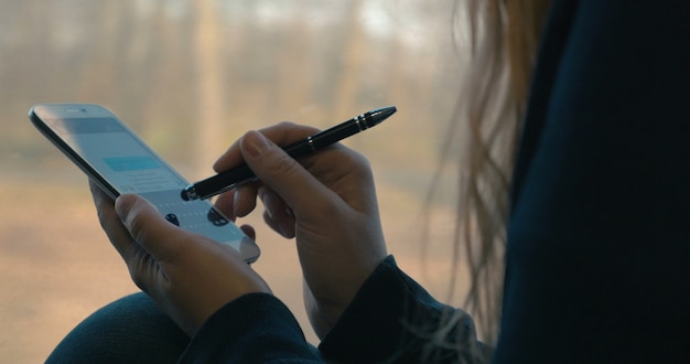 Ragazza che manda messaggi sullo smartphone in treno