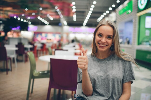 Ragazza che manda un sms sullo smartphone in un terrazzo del ristorante