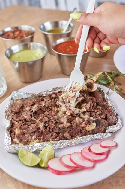 Ragazza che mangia delizioso cibo tipico messicano tacos sopes pastore ecc