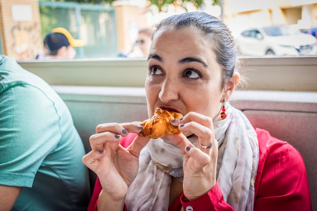 Ragazza che mangia pane per pranzo al ristorante al mattino