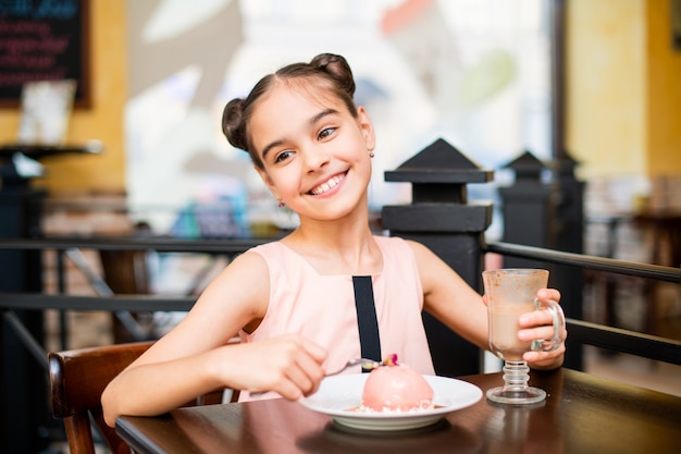 Ragazza che mangia una torta in un caffè