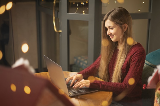 Ragazza che naviga in Internet al bar la sera