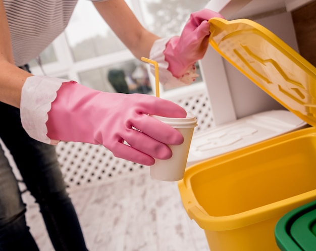 Ragazza che ordina immondizia alla cucina. Concetto di riciclaggio. Zero sprechi