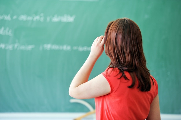 Ragazza che pensa sulla lavagna