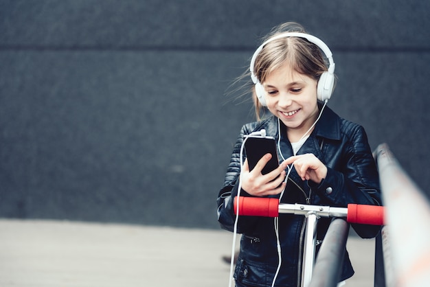 Ragazza che per mezzo dello Smart Phone all'aperto