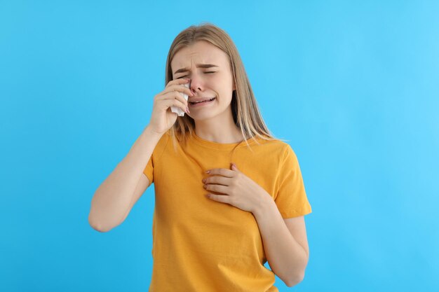 Ragazza che piange in maglietta su sfondo blu