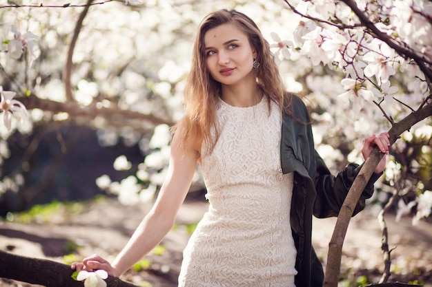 Ragazza che posa nel giardino della magnolia