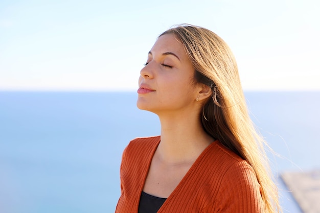 Ragazza che respira aria fresca con il mare blu