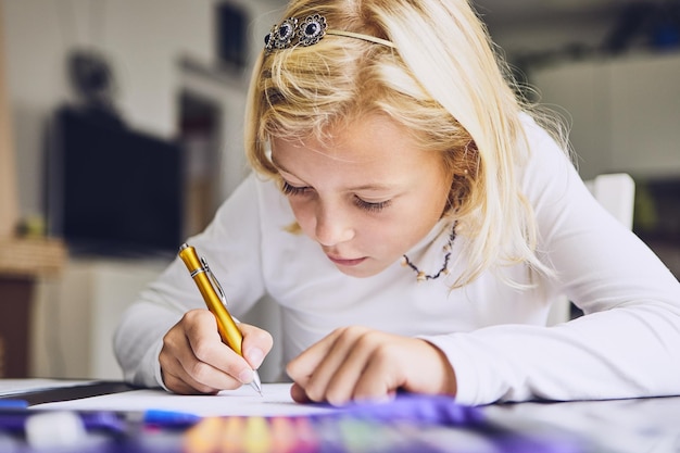 Ragazza che scrive su carta al tavolo