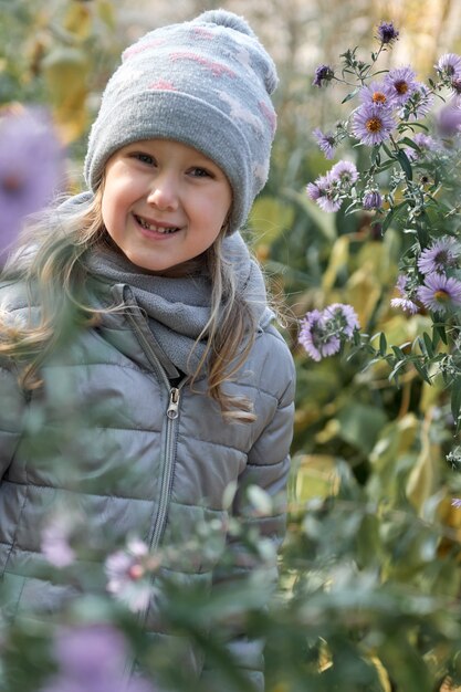 Ragazza che si diverte in un bellissimo parco con foglie secche gialle e rosse famiglia autunnale a piedi nella foresta