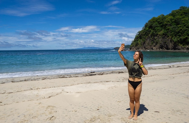 Ragazza che si fa un selfie sulla spiaggia