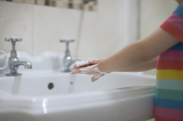 Ragazza che si lava le mani da sola in bagno
