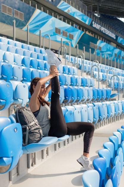 Ragazza che si siede sul sedile nello stadio.