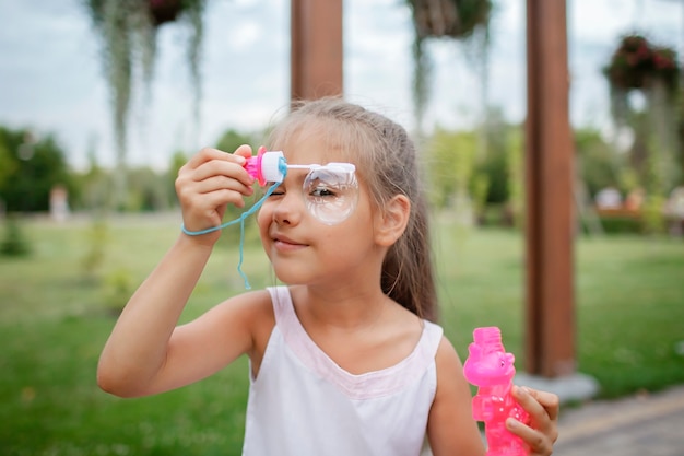 Ragazza che soffia bolle di sapone nel parco