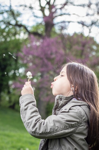 Ragazza che soffia un dente di leone