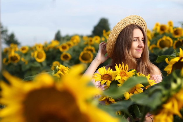 Ragazza che sorride in un giacimento del girasole