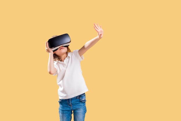 Ragazza che sperimenta il gioco delle cuffie VR. Emozioni sorprese sul suo viso. Bambino che utilizza un gadget di gioco per la realtà virtuale.