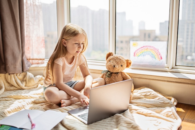 ragazza che studia i compiti durante la lezione online a casa