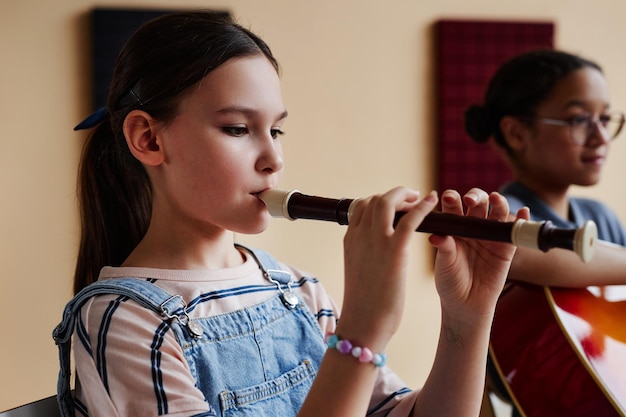 Ragazza che suona il flauto in classe di musica