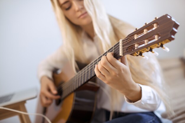 Ragazza che suona la chitarra a casa