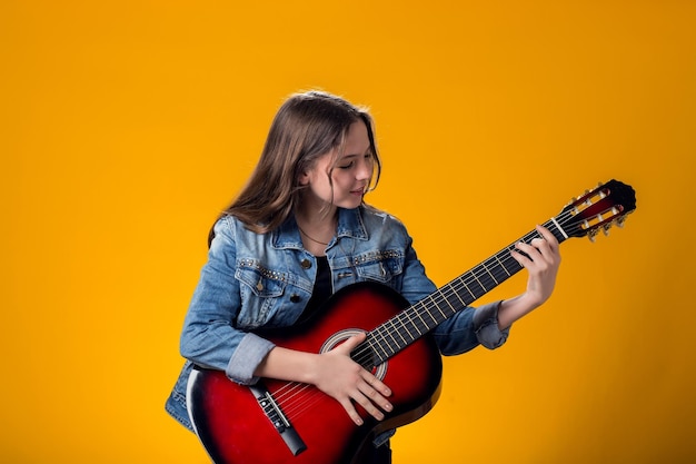 Ragazza che suona la chitarra su sfondo giallo