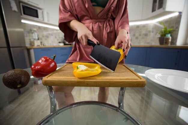 Ragazza che taglia le verdure in cucina