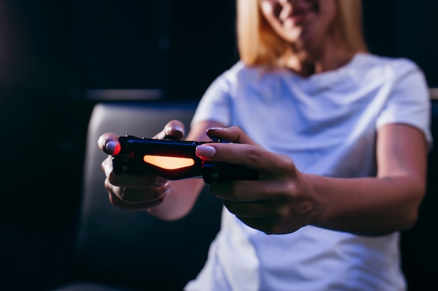 Ragazza che tiene in mano il gamepad e giocare ai videogiochi