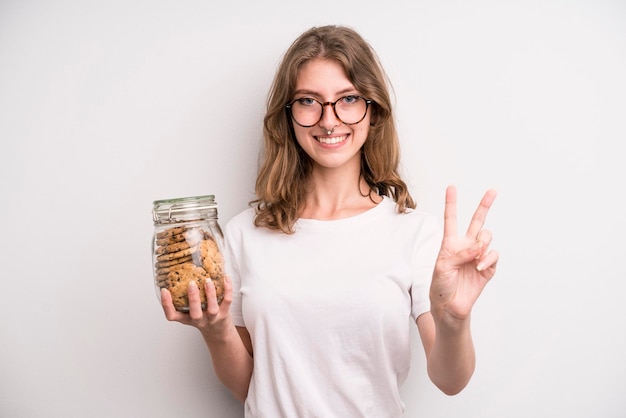 Ragazza che tiene la bottiglia fatta in casa dei biscotti