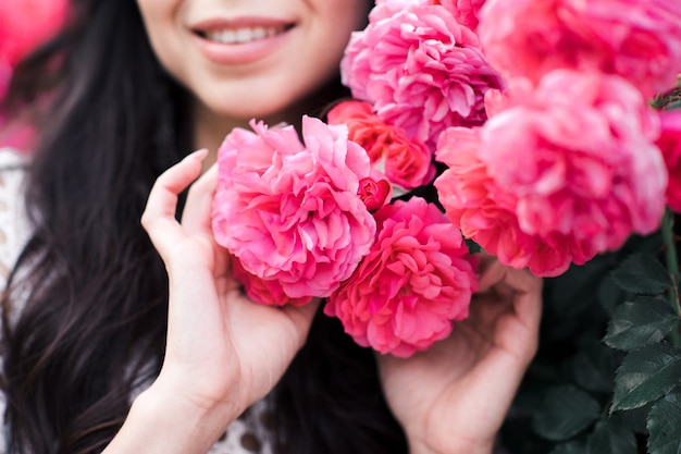 Ragazza che tiene le rose fresche rosa