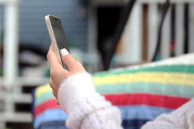 Ragazza che tiene lo smartphone e invia un messaggio di testo