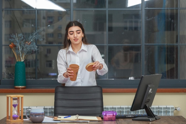 Ragazza che tiene tazza di caffè e guardandola