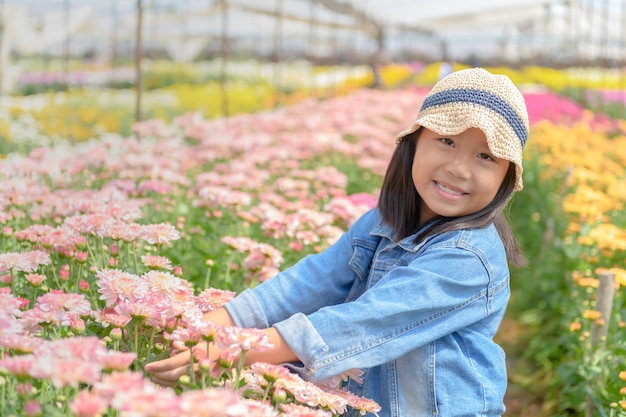 Ragazza che tiene un mazzo di fiori colorati di crisantemo,