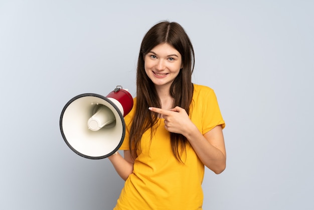 Ragazza che tiene un megafono e con l'espressione facciale di sorpresa