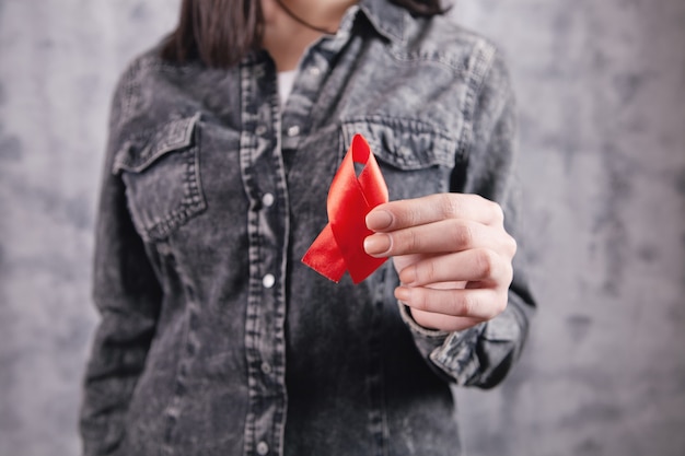 Ragazza che tiene un nastro rosso di aiuti nelle sue mani