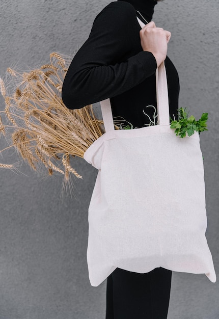 Ragazza che tiene un sacchetto di stoffa con spighe di grano