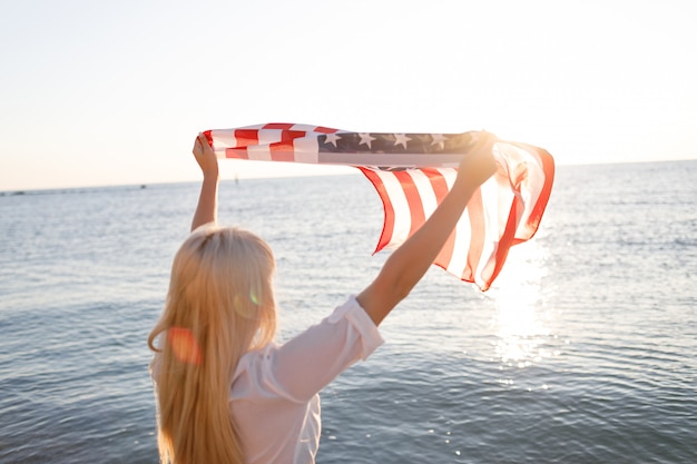 Ragazza che tiene una bandiera americana