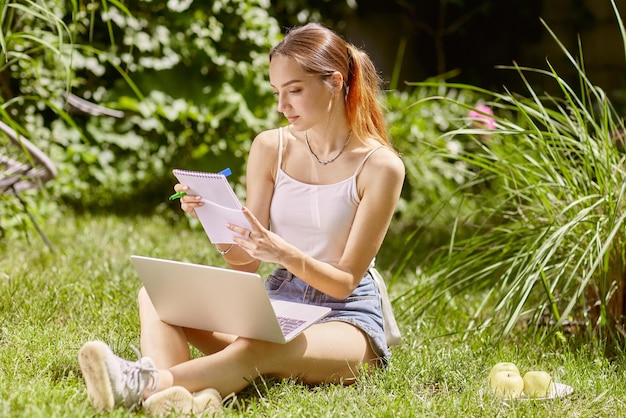 Ragazza che tiene una riunione online e chatta in natura