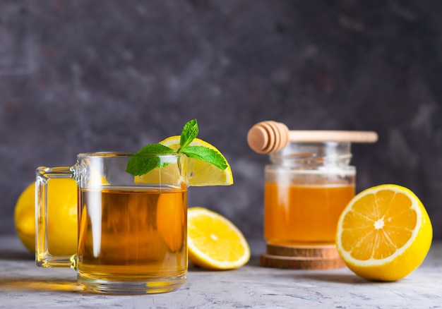 Ragazza che tiene una tazza di tè con limone e miele