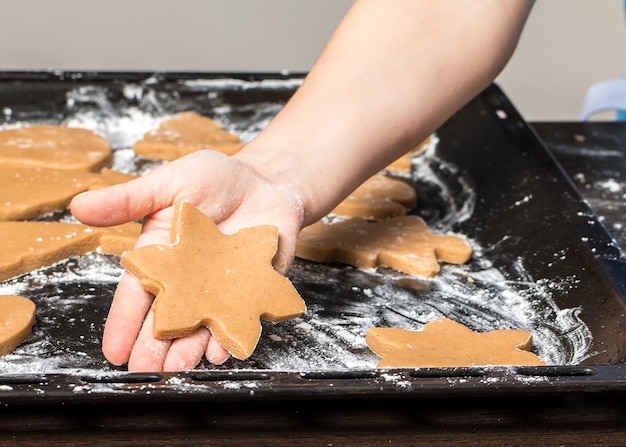 Ragazza che tiene una teglia con i biscotti allo zenzero appena sfornati